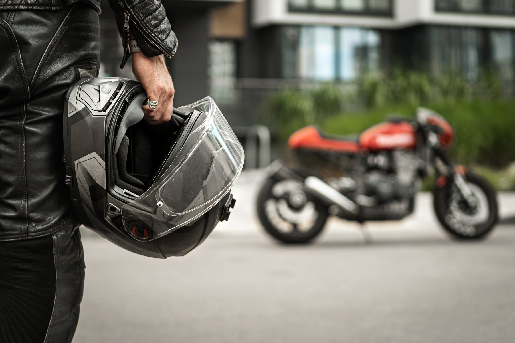 Motociclista con il casco in mano accanto alla moto presa a noleggio a Lamezia Terme
